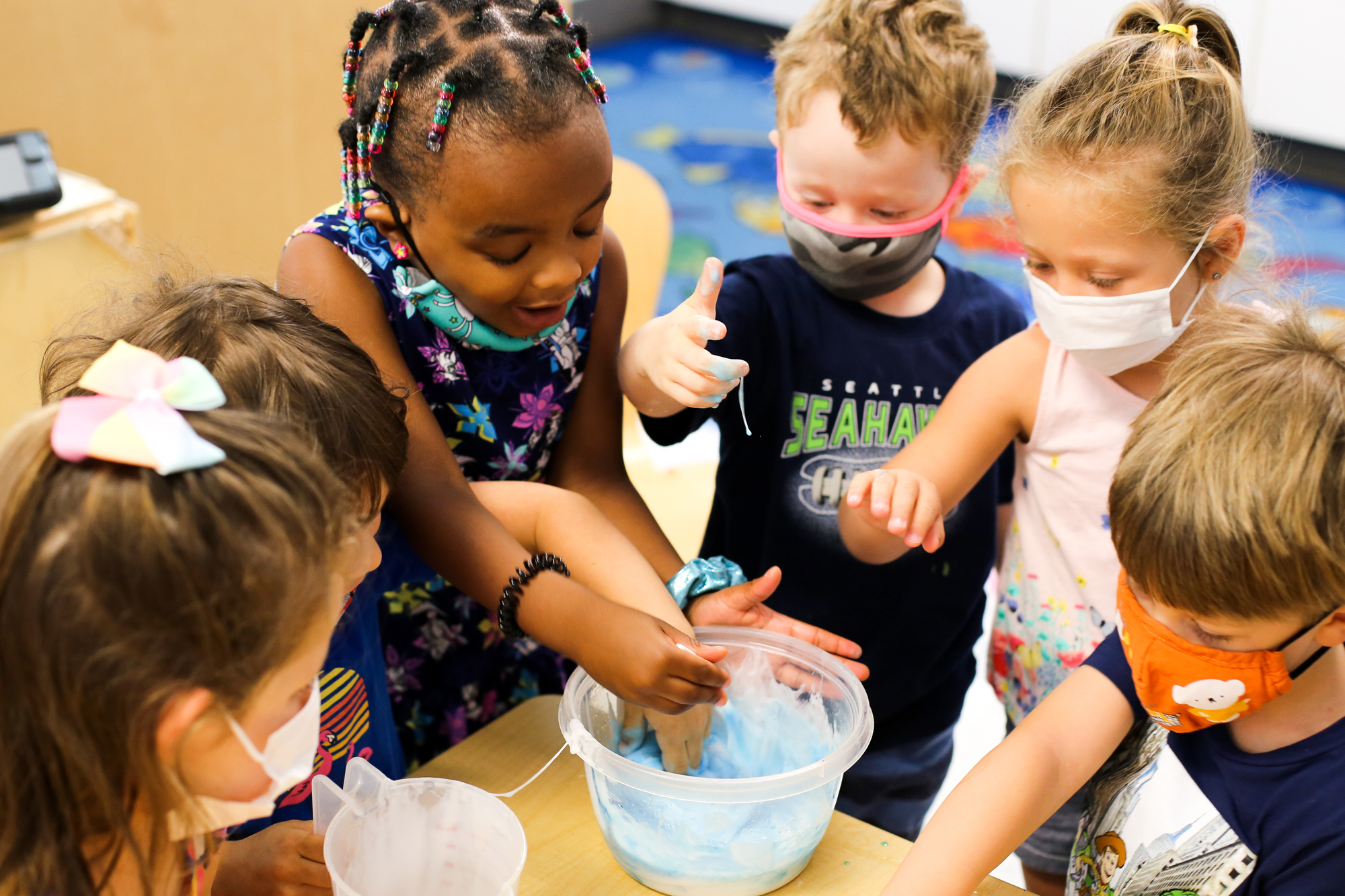 A group of Pre-K students experimenting with slime. 