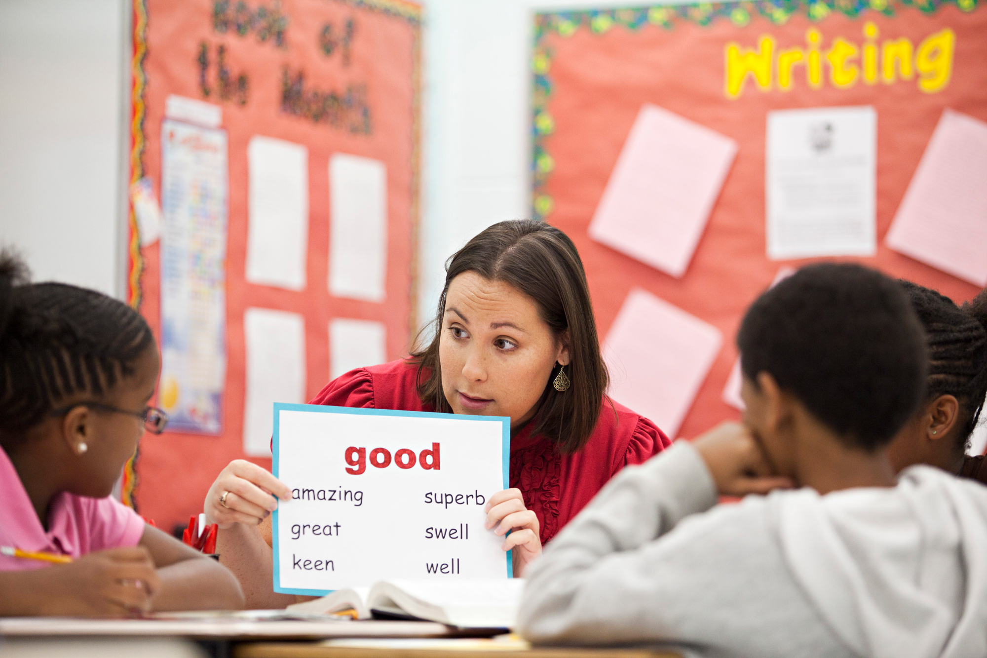 A teacher working on literacy skills with a group of students. 