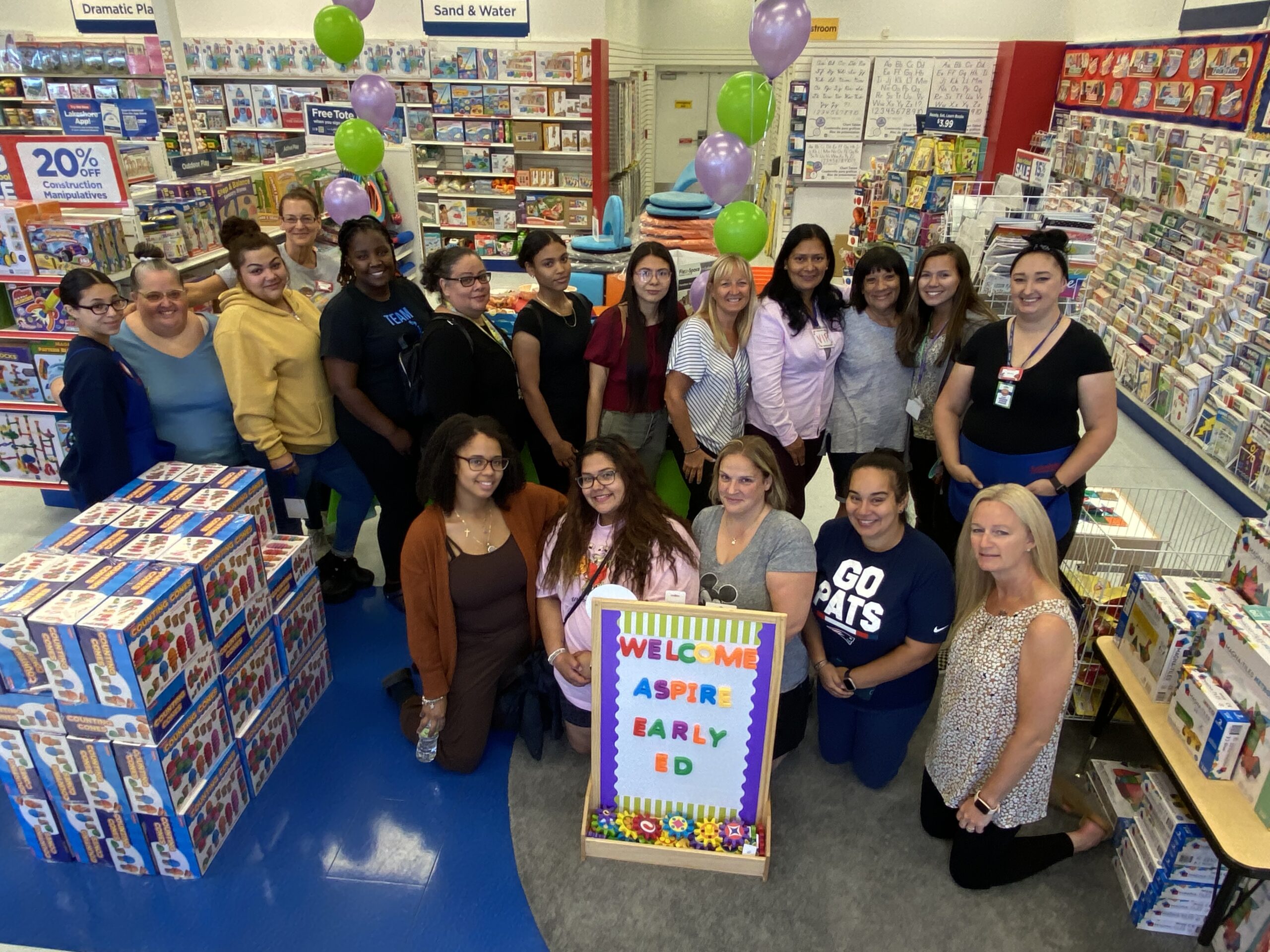 12 teachers accompanied by various program leaders and employees stand in the Lakeshore Learning store.