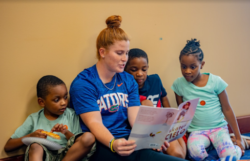 UF athlete reads to a group of children.