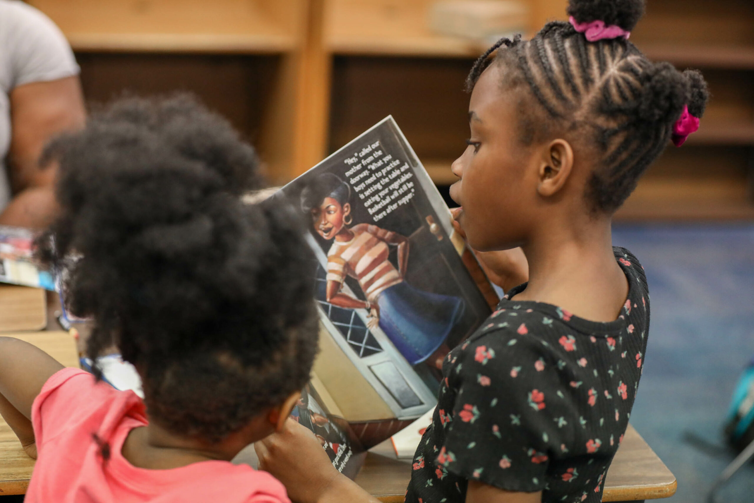 An elementary age student reads a book in the library.