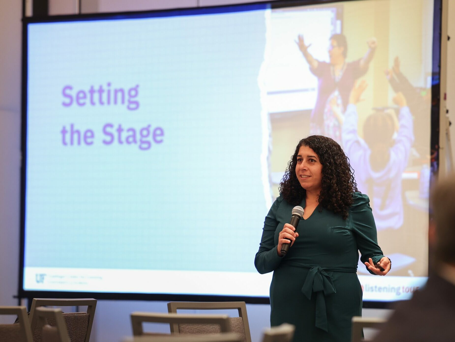 A photo of a woman speaking at the Math Summit in front of a presentation slide that says, "Setting the Stage."